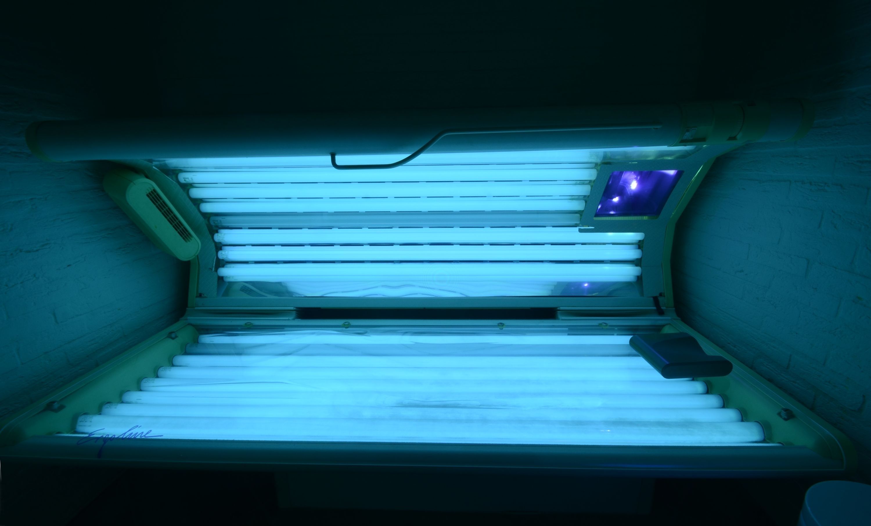 A tanning bed with multiple light panels and a control panel.