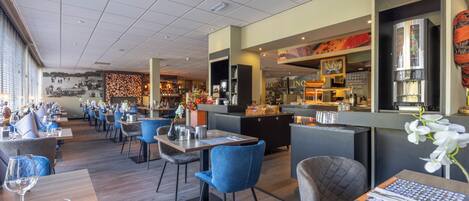 A restaurant with multiple tables and chairs, a bar area, and a mural on the wall.