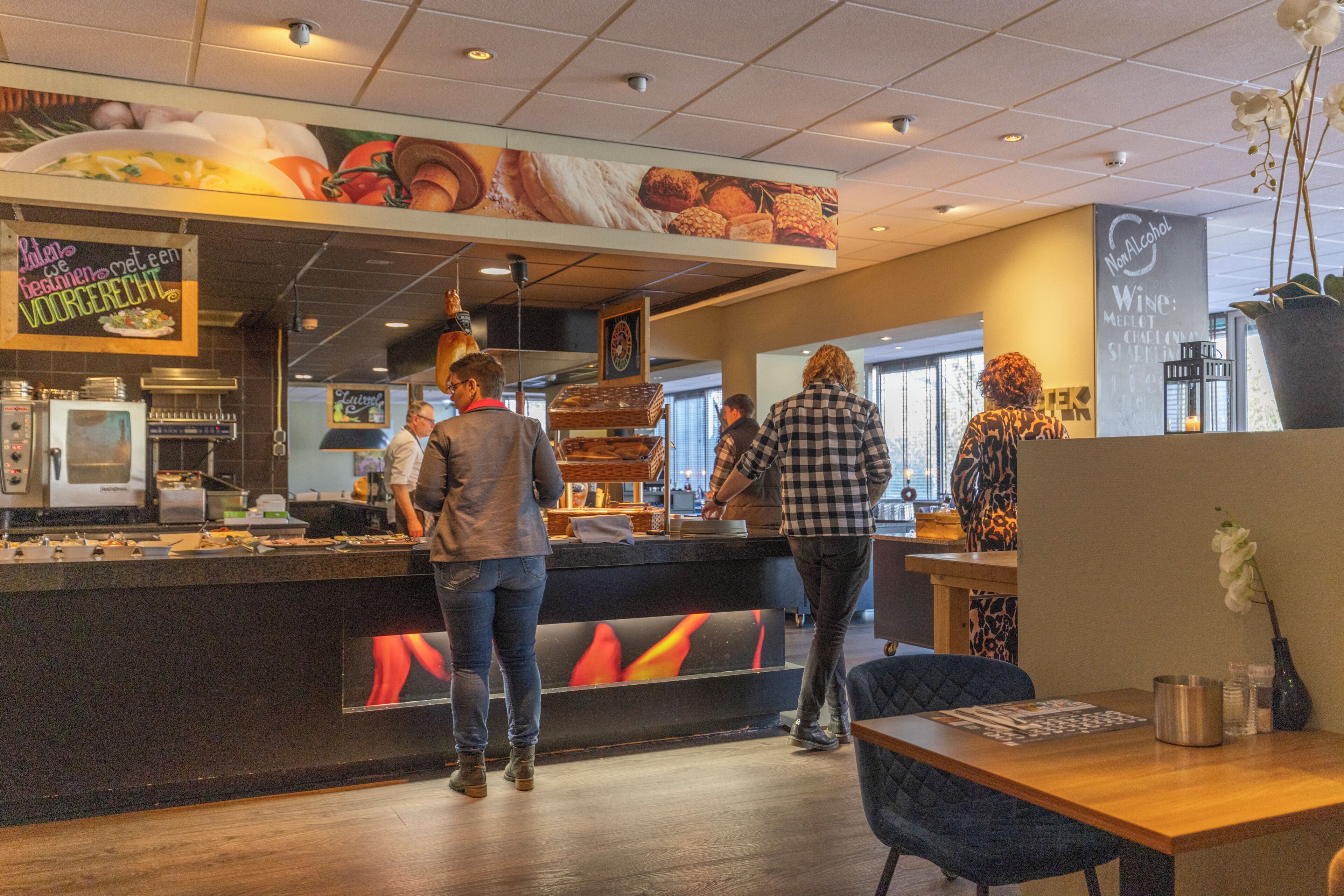 A restaurant interior with a counter, seating area, and a menu board.