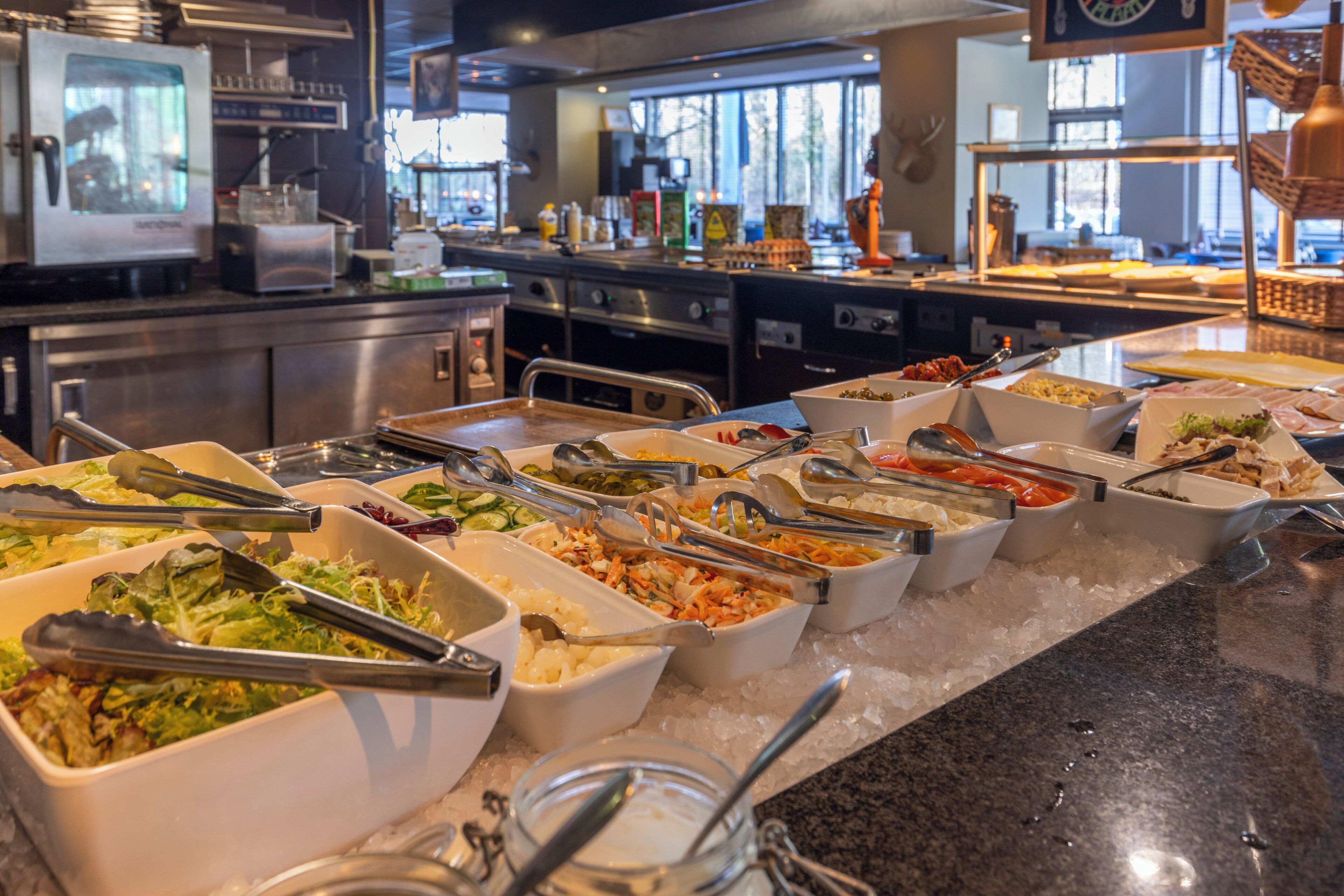 A buffet with various food options and serving utensils.