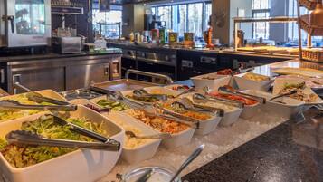A buffet with various food options and serving utensils.