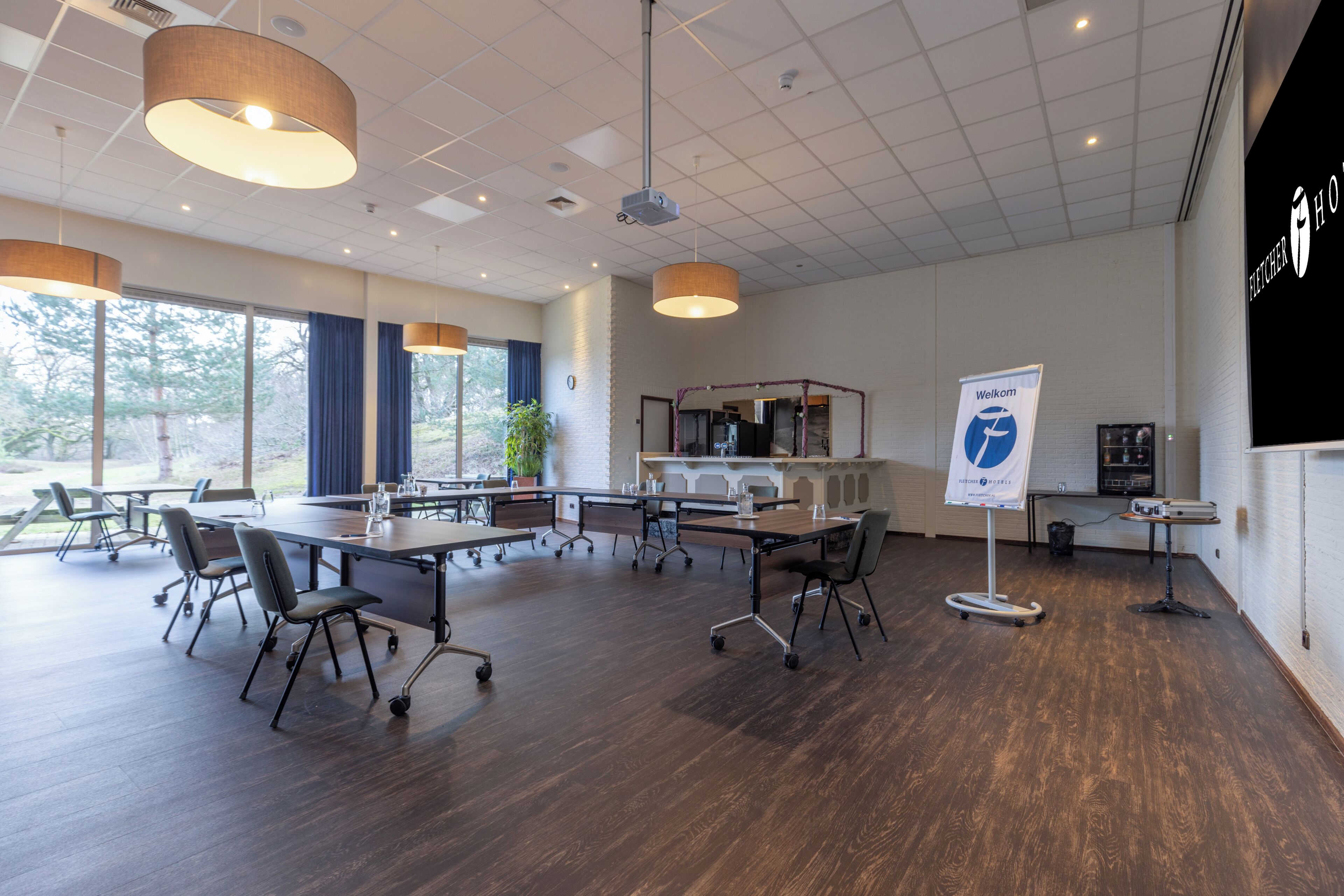 A conference room with a long table, chairs, and a projector.