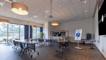 A conference room with a long table, chairs, and a projector.