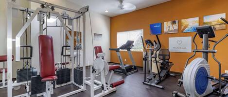 A gym with various exercise equipment, a treadmill, and a stationary bike.