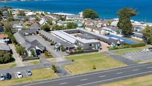 An aerial view of a residential area with houses, a large building with a flat roof, and a parking lot. - Quality Inn Acapulco Taupo (Taupo)