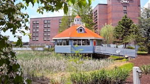 Ein Hampton Inn Hotel mit einem markanten, rot gedeckten Gebäude und einem blauen Bauwerk mit einem weißen Balkon.