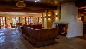 A cozy interior with a wooden bench seating area, a fireplace, and a sign indicating a gift shop.