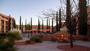 A courtyard with outdoor seating, a fire feature, and a view of the surrounding buildings.