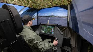 Cabina de piloto con panel de control y vista de una pista.