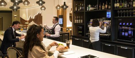 A bar area with a counter, bar stools, and a bartender.