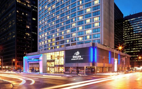 A modern hotel building with a prominent entrance and illuminated signage.