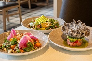 Tres platos de comida con diversos ingredientes y adornos.