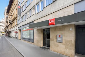A hotel entrance with a modern facade, a clear sign indicating 'ibis Budapest City,' and a visible parking sign. - ibis Budapest City (Budapest)