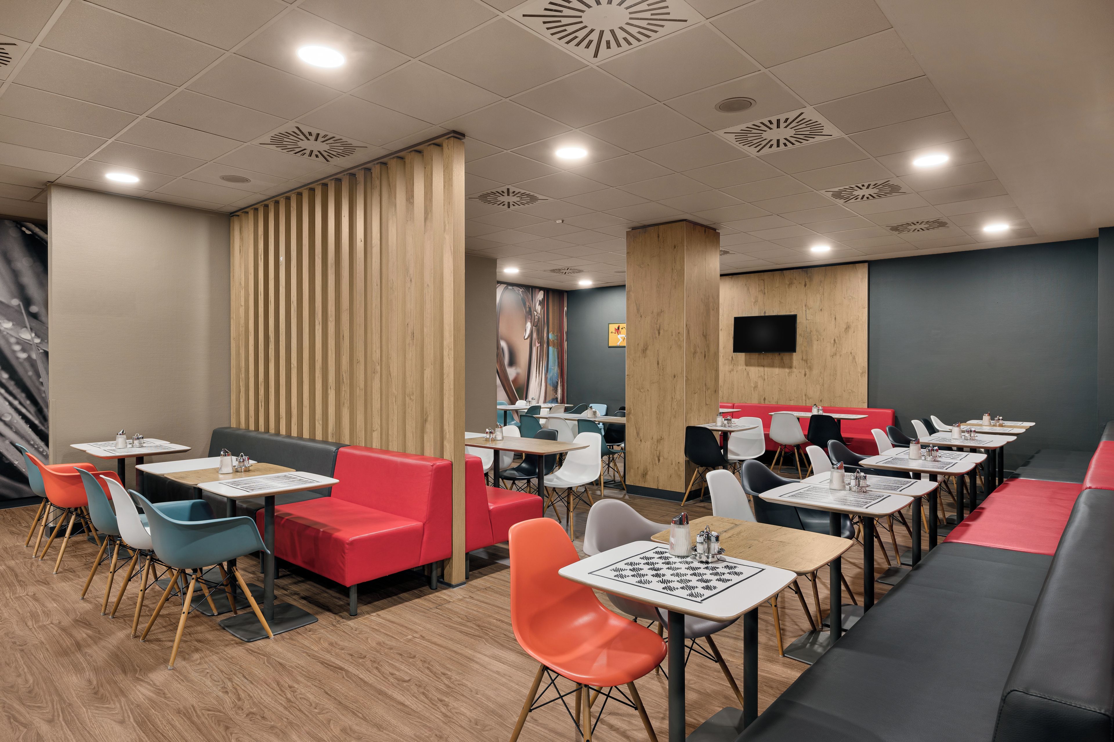 A modern restaurant interior with booths, tables, and a variety of seating options.