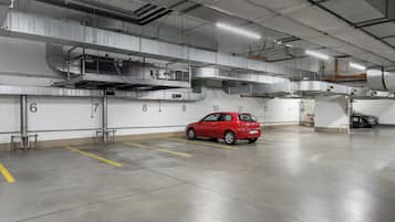 Uma garagem de estacionamento com um carro vermelho estacionado em uma vaga numerada 10.