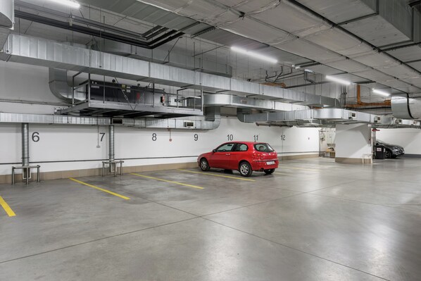 A parking garage with a red car parked in a spot marked with the number 10. - ibis Budapest City (Budapest)