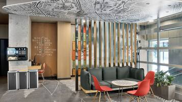 A modern interior with a seating area, a wall with text, and a view through a glass partition.