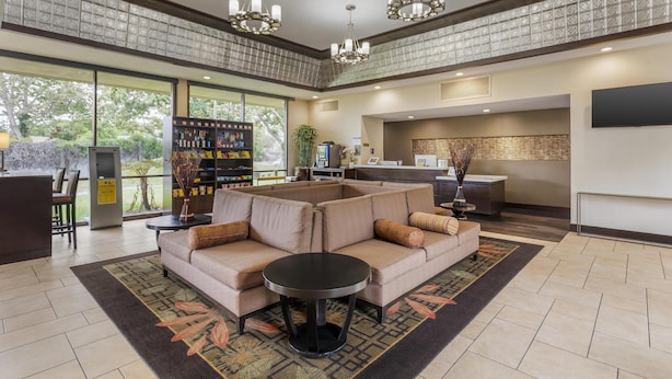 A spacious lobby with a sectional sofa, a round table, and a bar area. - Best Western Plus Garden Court Inn (Fremont)