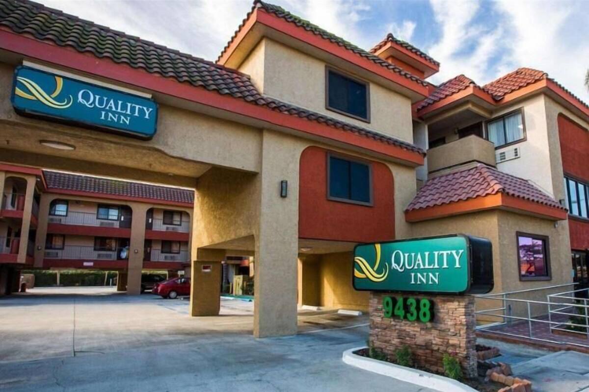 A hotel with a sign reading 'Quality Inn 9438' and a building with multiple balconies.