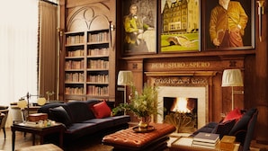 A traditional library with bookshelves, a fireplace, and classic furniture.