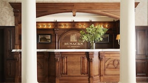 A reception desk with a wooden finish, a marble top, and a framed sign reading "RUSACKS ST ANDREWS."