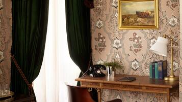 Una habitación con escritorio, silla y un cuadro en la pared.