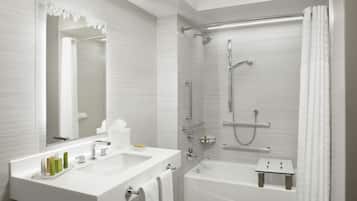 Un baño moderno con tocador doble, bañera, ducha con puerta de cristal y un espejo grande.