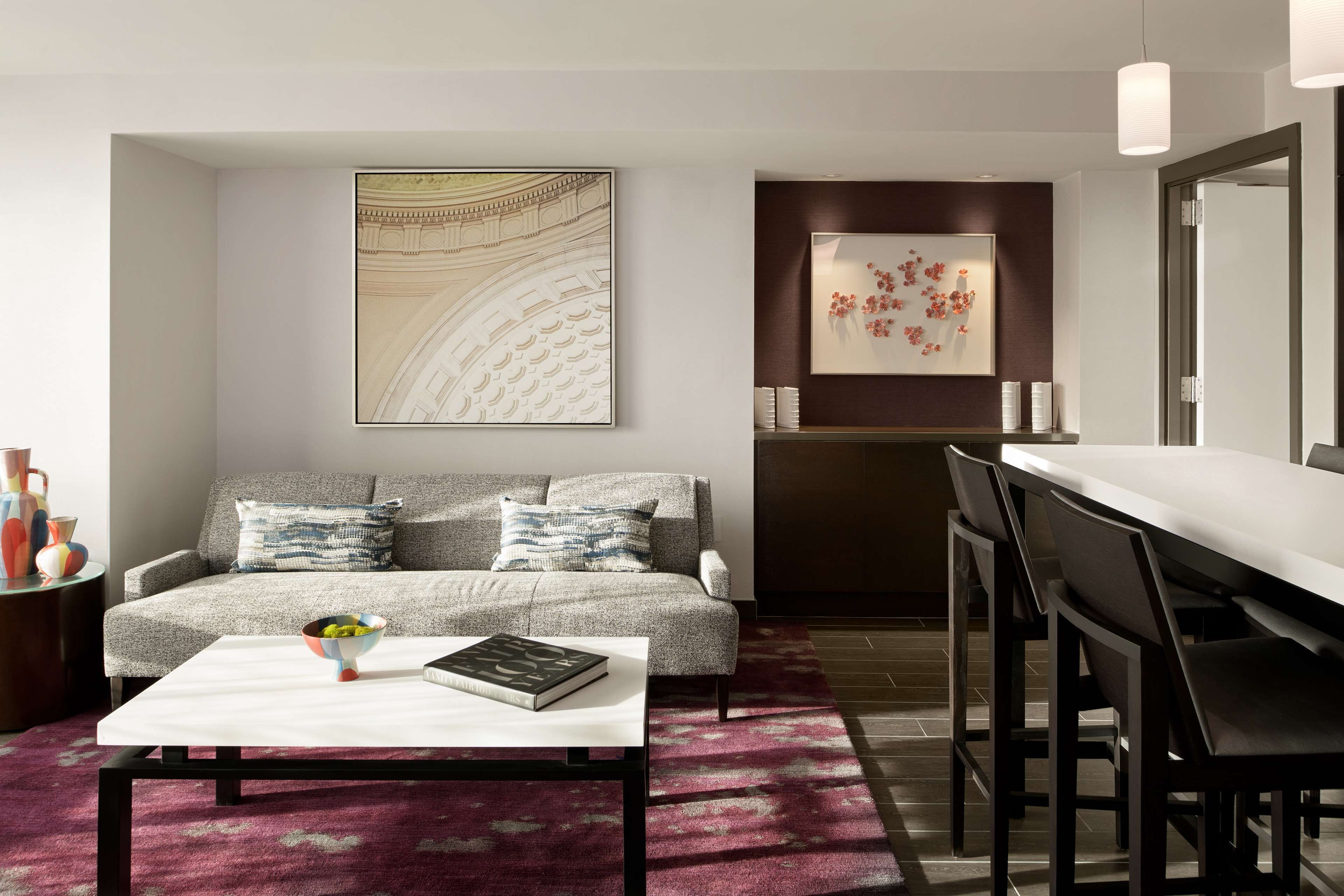 Un salon moderne avec un canapé, une table basse et un coin repas.