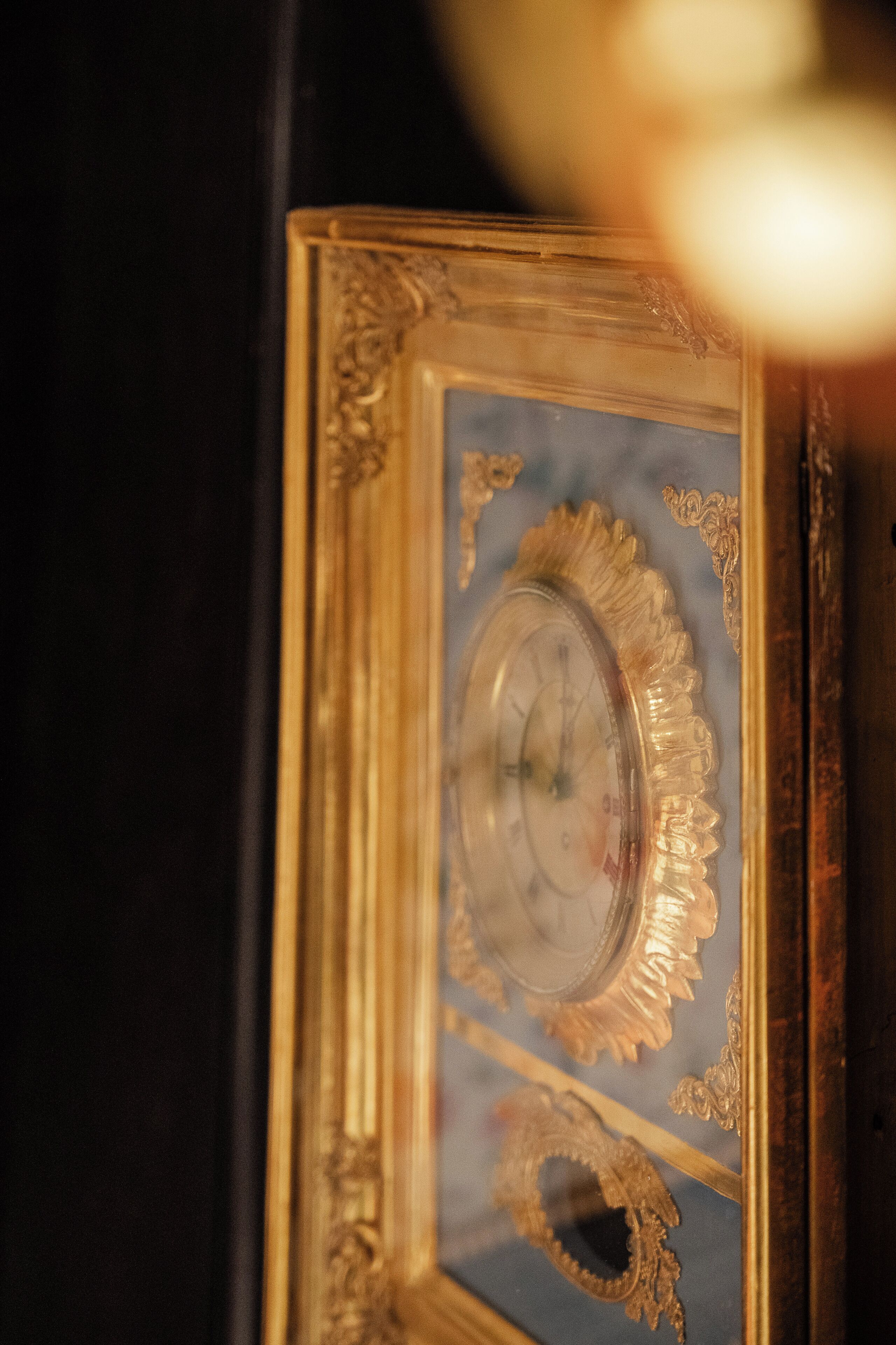 Un primo piano di uno specchio decorato, con cornice dorata e dettagli elaborati.