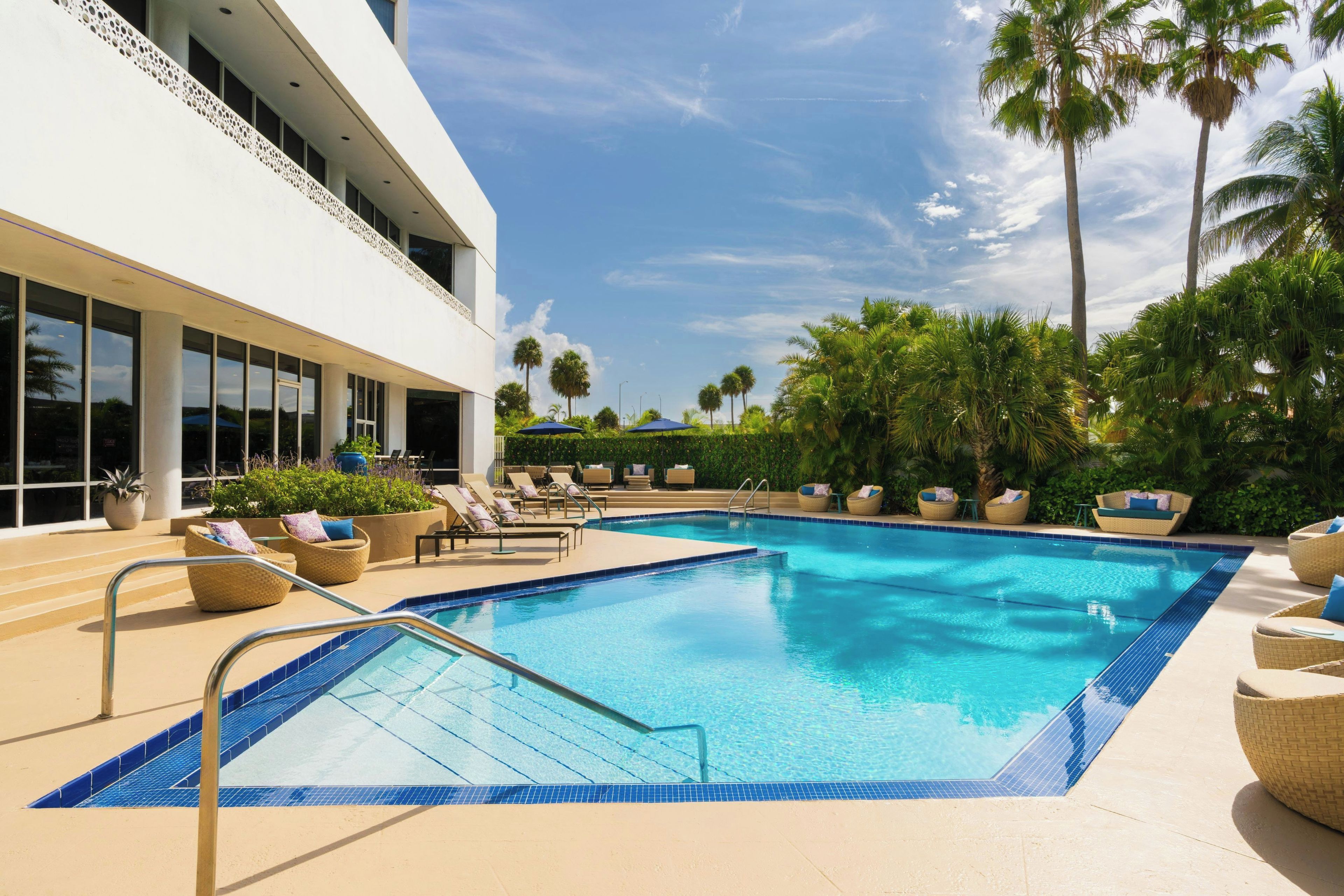 A pool area with lounge chairs and a clear blue pool.