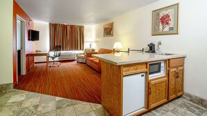 A compact hotel room with a kitchenette, a dining area, a sofa, and a TV. - Quality Inn Aberdeen (Aberdeen)