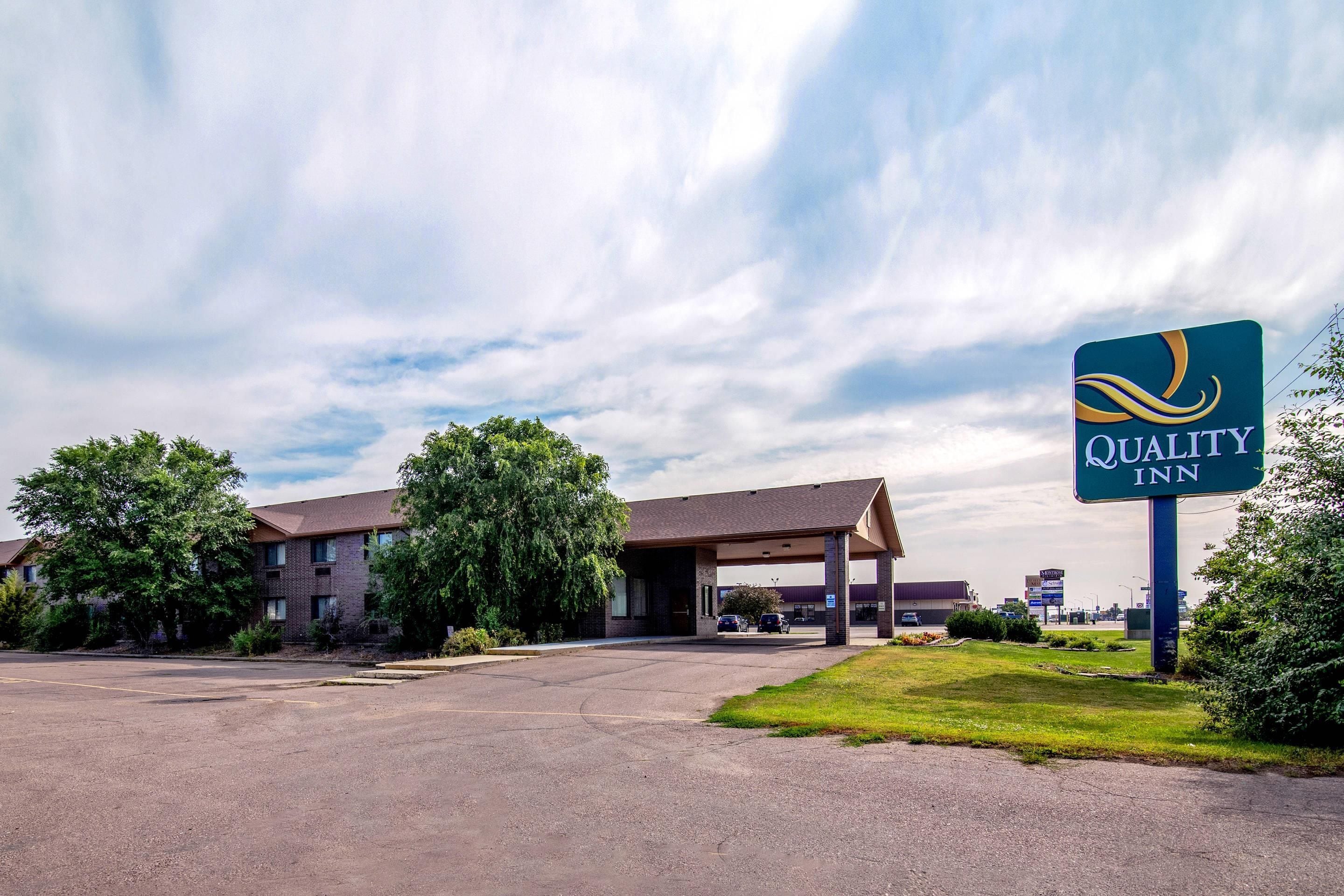 A Quality Inn hotel with a parking lot and a covered parking structure.