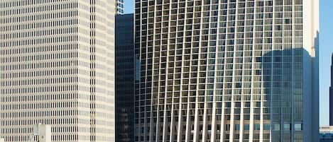 Un hotel Marriott Marquis con fachada de vidrio moderna, rodeado de otros edificios altos.