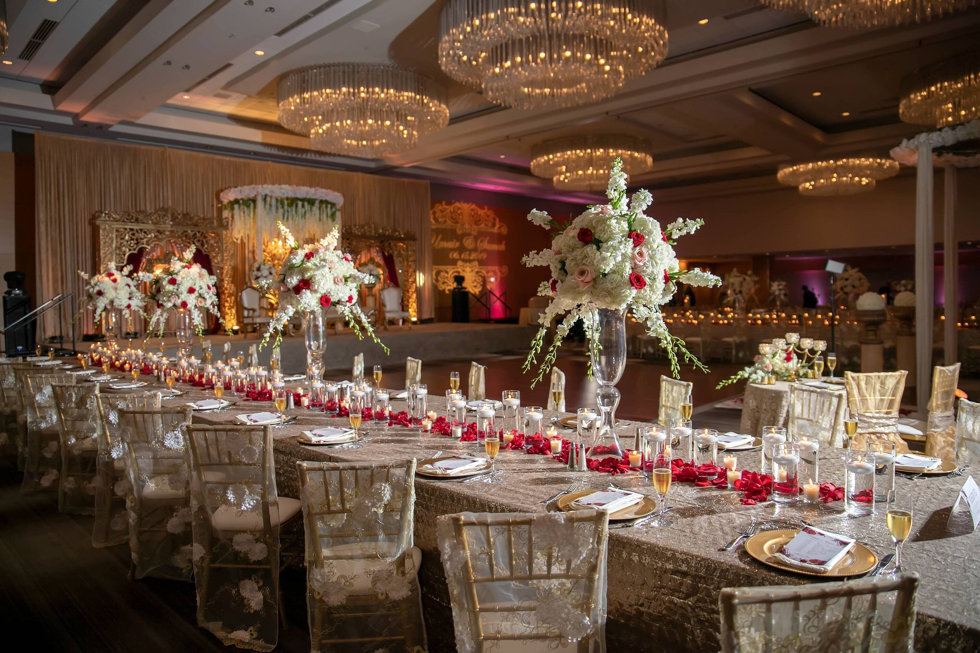 Une salle de banquet avec des tables rondes, des chaises et des lustres.