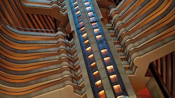 Ein mehrgeschossiges Atrium mit einer zentralen Treppe, umgeben von Balkonen.