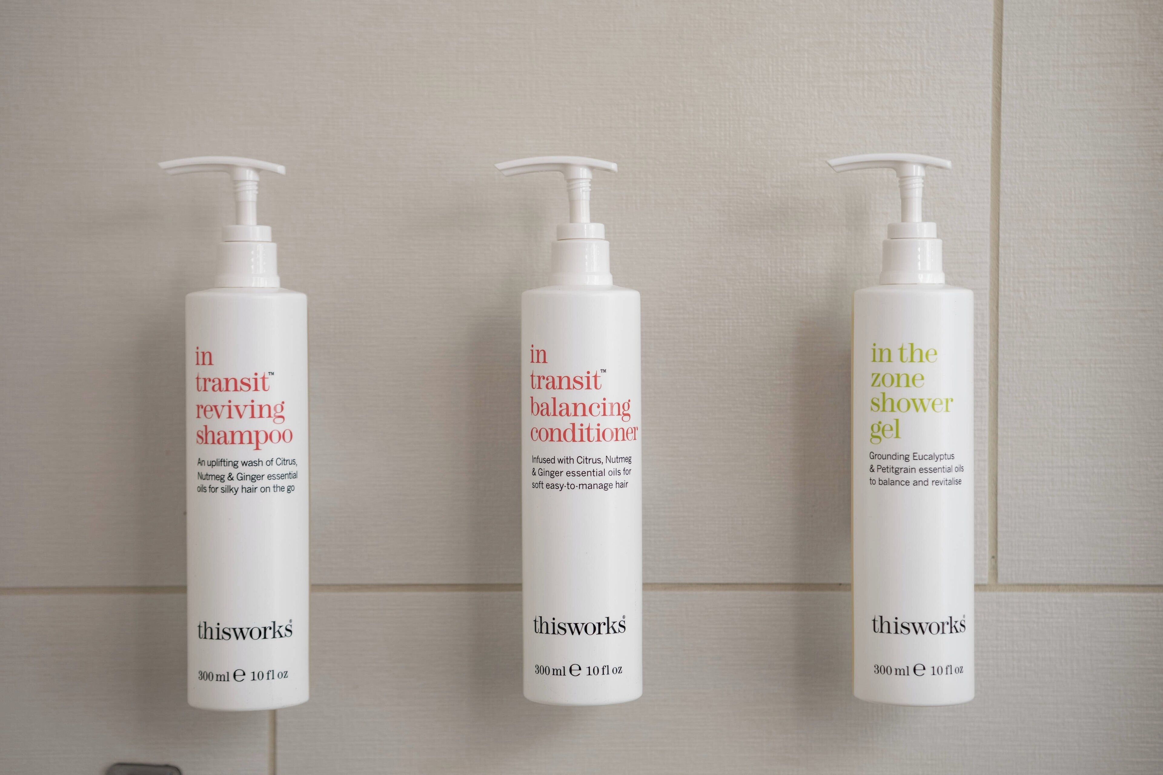 Tres botellas de champú, acondicionador y gel de ducha de thisworks.