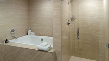 Un baño moderno con bañera, ducha y cabina de ducha con paredes de vidrio.