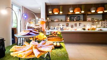A buffet setup with various food items and a modern kitchen in the background.