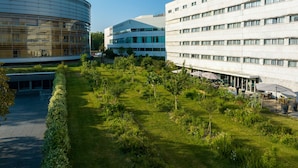 Un ensemble immobilier moderne composé d’une structure circulaire et d’un bâtiment rectangulaire doté de nombreuses fenêtres.