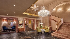 A spacious lobby with a marble floor, a chandelier, a staircase, and seating areas. - Hotel Accademia (Verona)