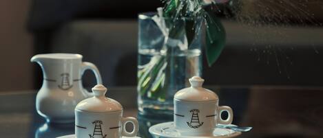 A table with a tea set and a vase with flowers.