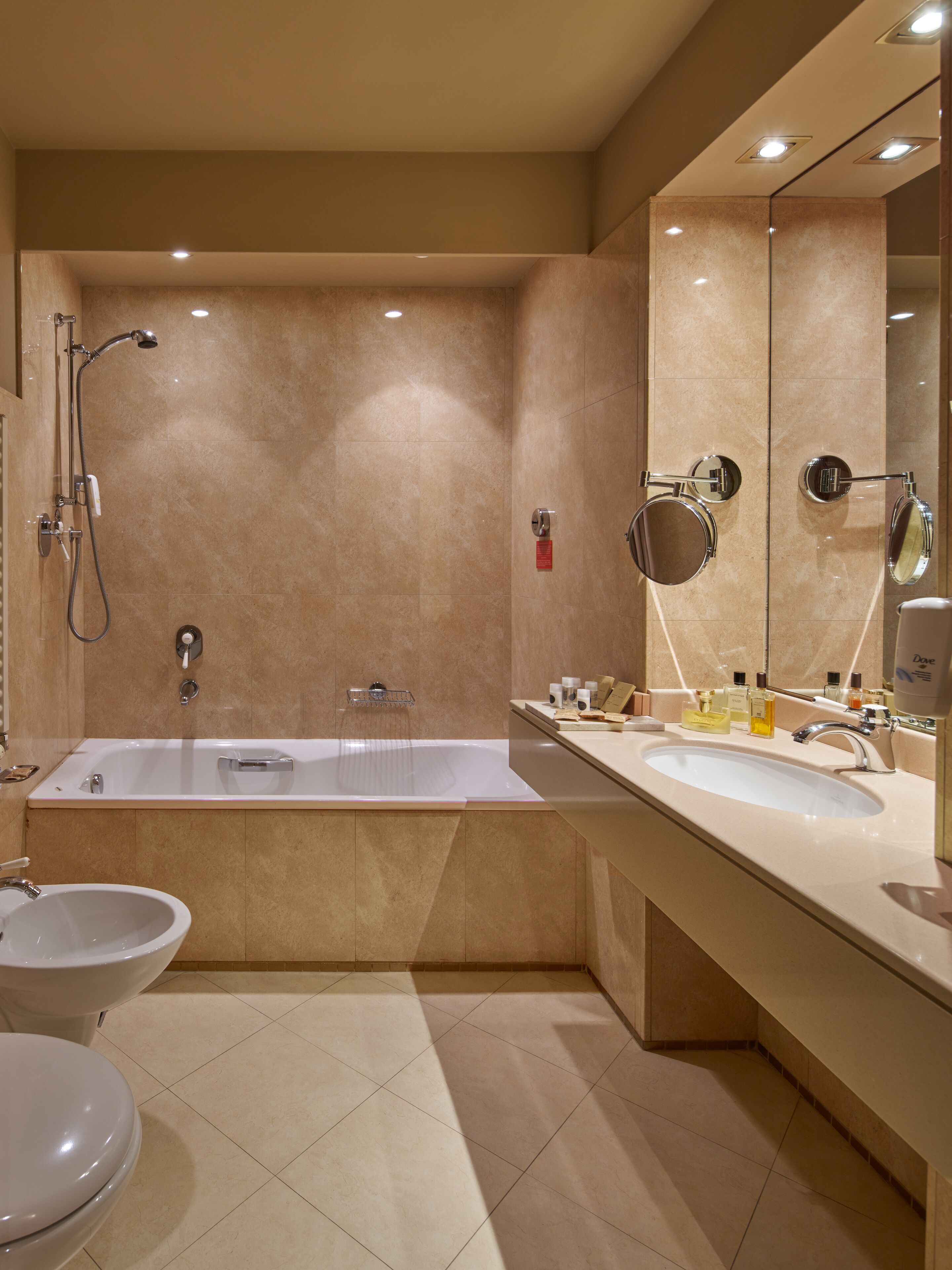 Une salle de bain moderne équipée d’une baignoire, de deux lavabos, de toilettes et d’une douche.