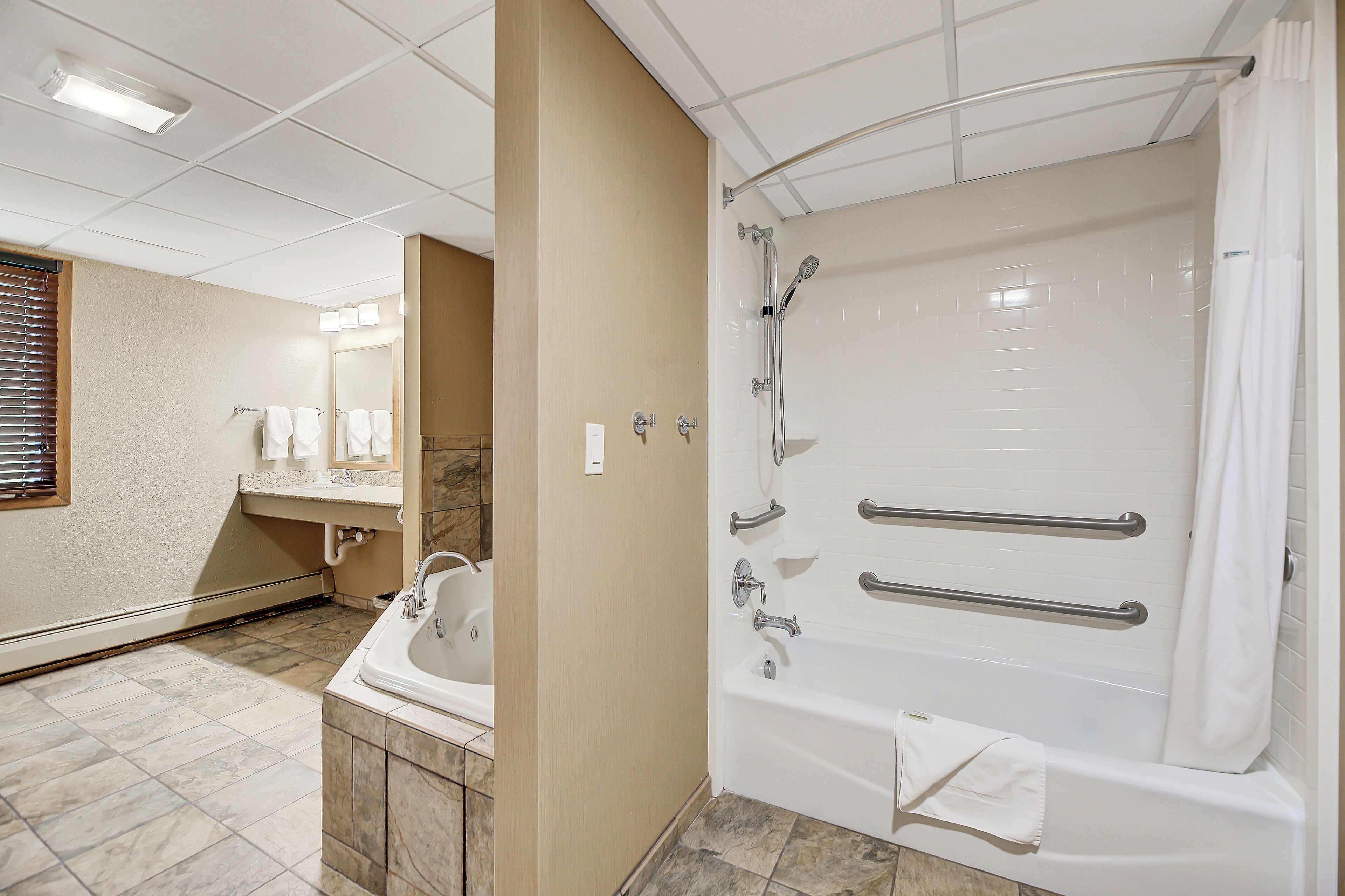 A modern bathroom with a walk-in shower, a bathtub, and a vanity with a sink.