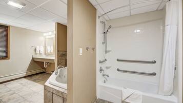 A modern bathroom with a walk-in shower, a bathtub, and a vanity with a sink.