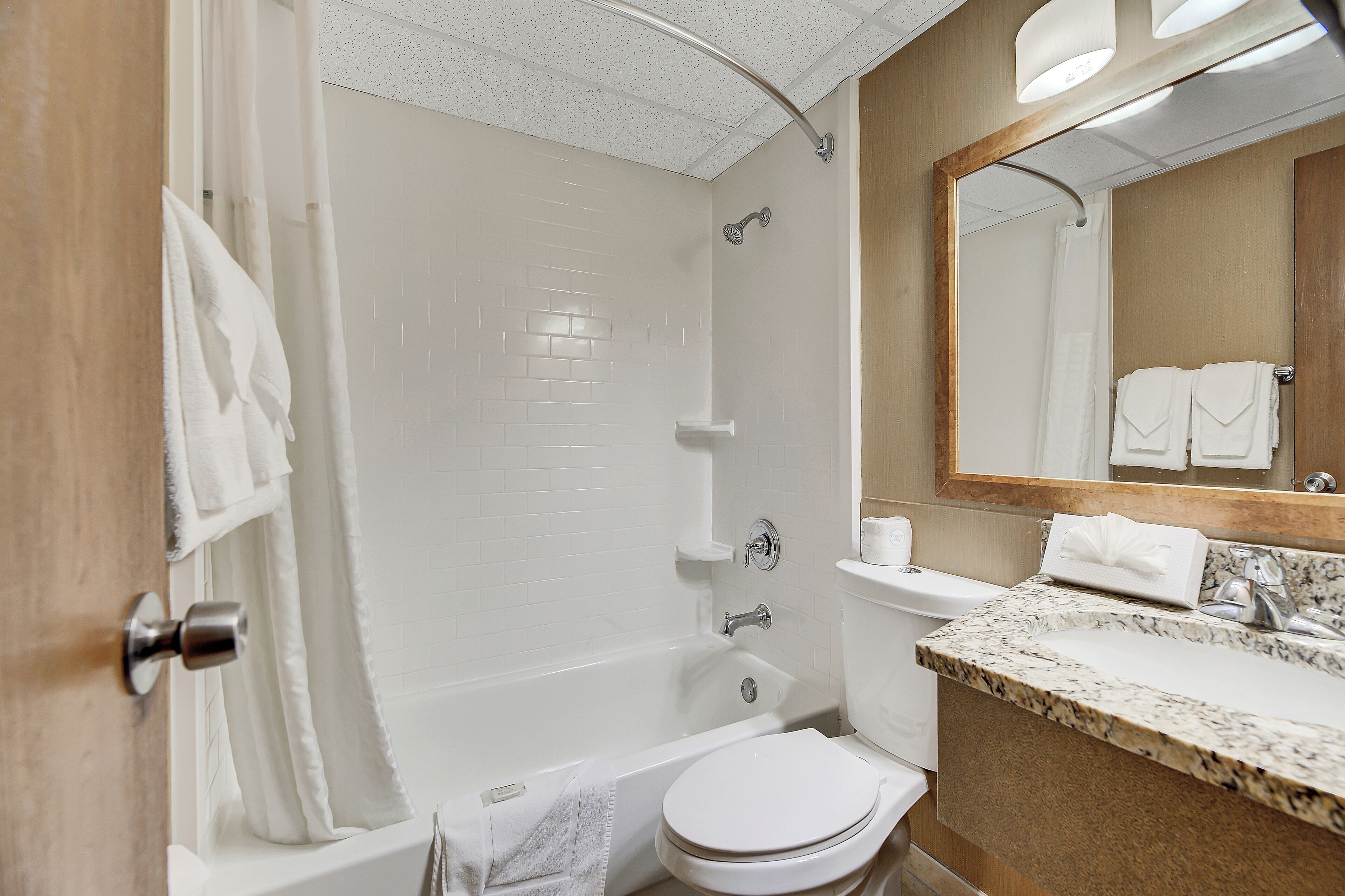 A modern bathroom with a bathtub, toilet, and sink.