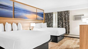 A hotel room with two beds, a large painting above the beds, a wooden headboard, a desk with a lamp, and a window with curtains. - Days Inn by Wyndham Helena (Helena)