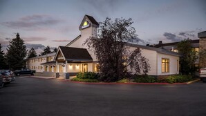A Days Inn with a prominent 'Days Inn' sign on the roof, a parking lot, and a well-maintained exterior with a large tree in front. - Days Inn by Wyndham Helena (Helena)