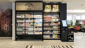 Et madmarked med et køledisk og en selvbetjenings kiosk.