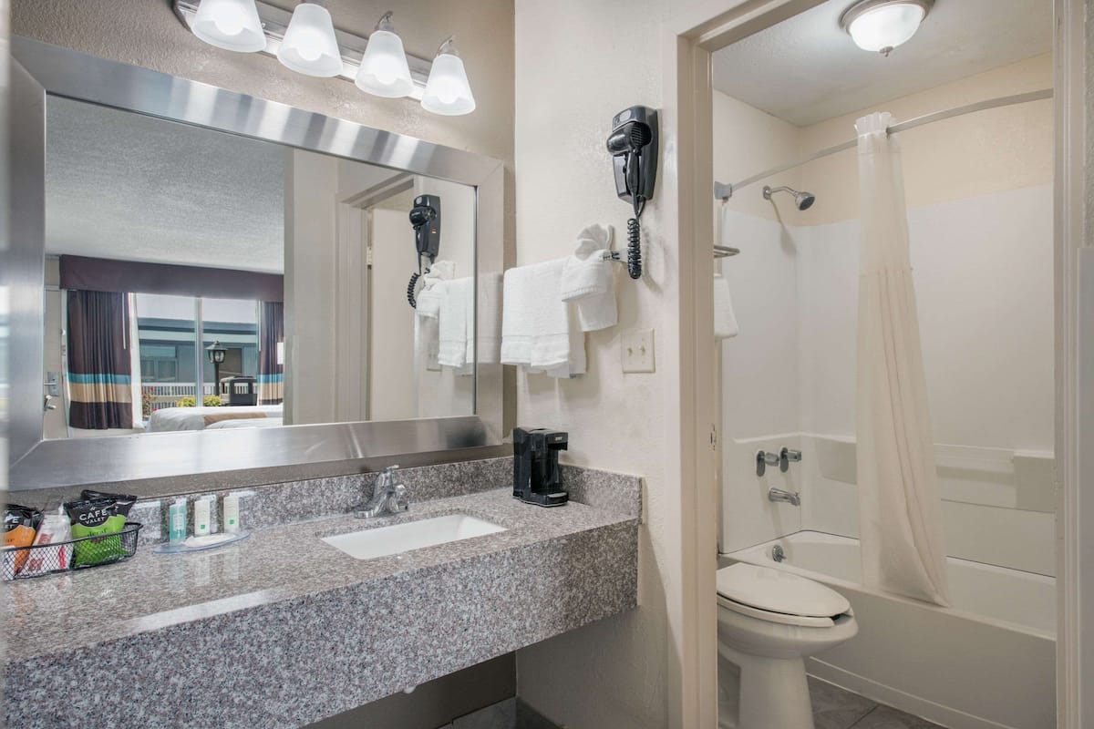 Habitación estándar, 2 camas matrimoniales, para no fumadores | Baño | Tina con regadera, amenidades de baño gratuitas, secadora de cabello