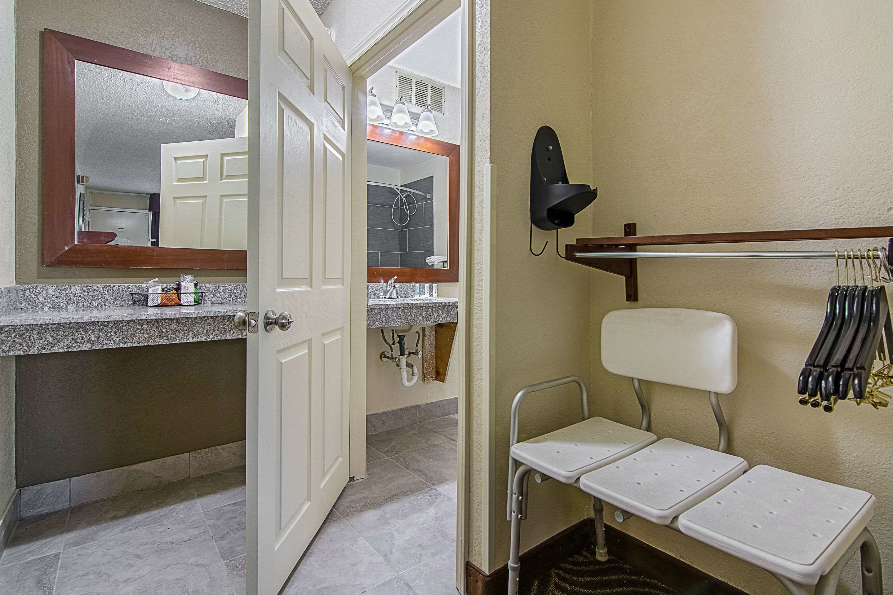 Un baño con espejo, lavamanos, ducha y retrete.